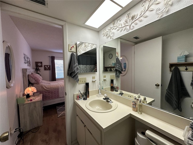 bathroom with vanity, wood-type flooring, and a skylight