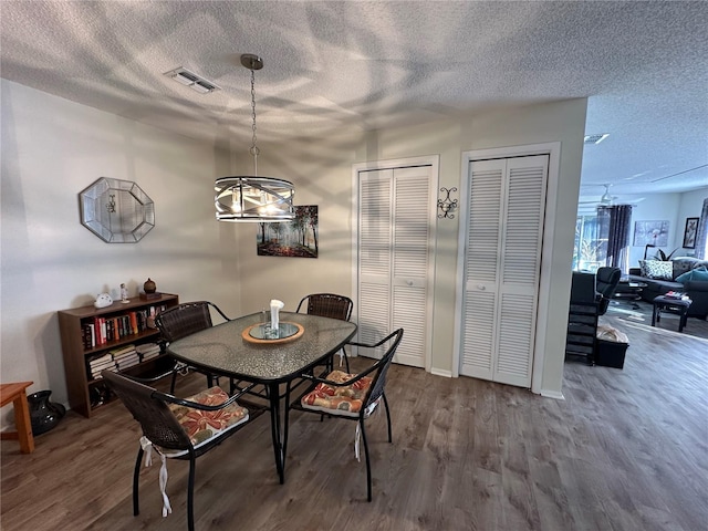 dining room with hardwood / wood-style flooring and a textured ceiling