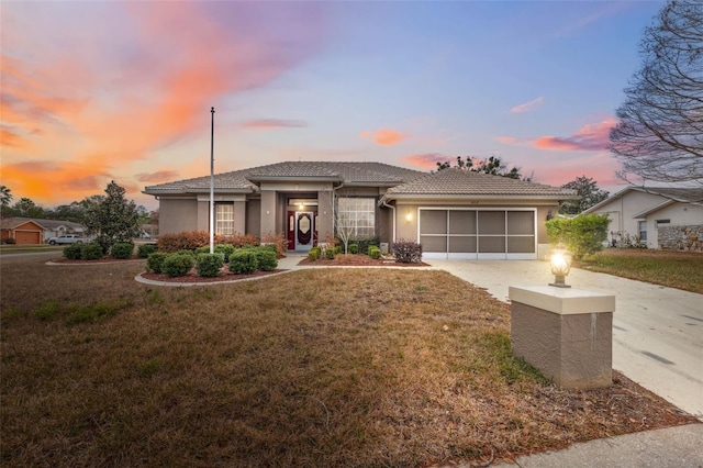 prairie-style home featuring a garage and a lawn