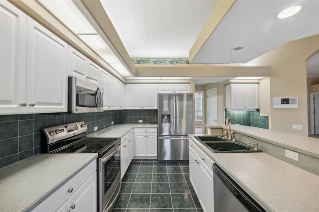 6112 Kinlock Ave, Spring Hill, FL 34608 - kitchen with stainless steel appliances, a sink, white cabinetry, decorative backsplash, and recessed lighting