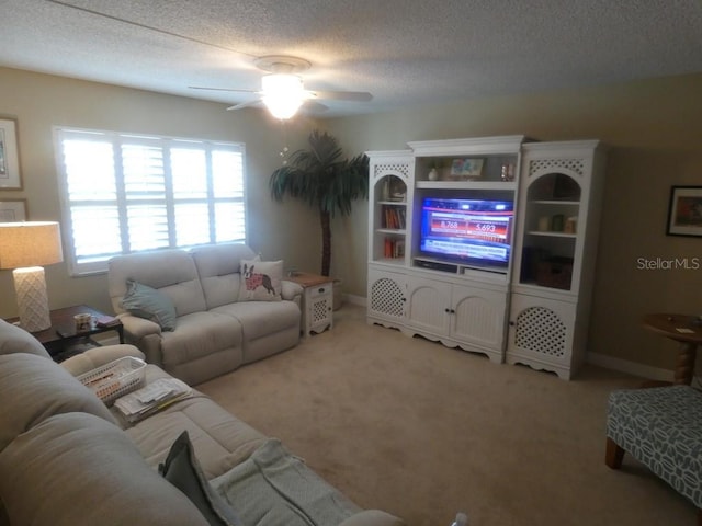 living room with ceiling fan, light colored carpet, and a textured ceiling