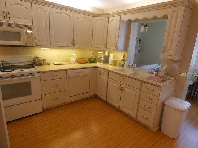 kitchen featuring sink, white appliances, and light hardwood / wood-style flooring