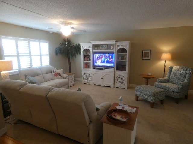 living room with ceiling fan, carpet, and a textured ceiling