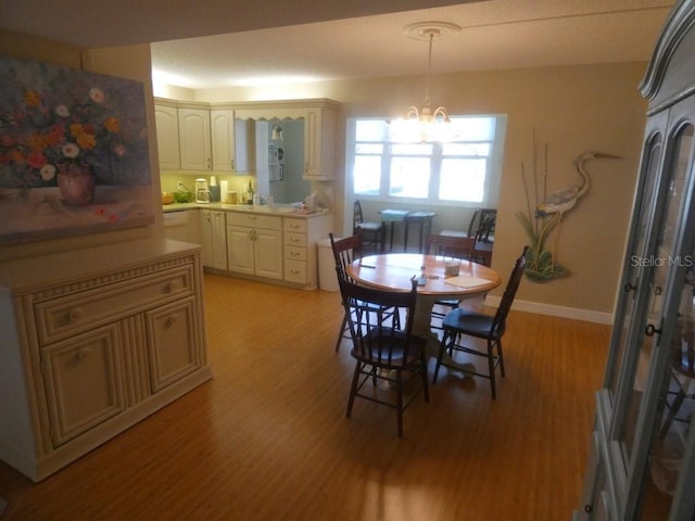 dining room with light hardwood / wood-style flooring and a notable chandelier