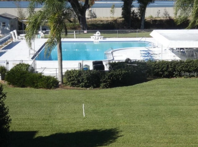 view of pool featuring a lawn