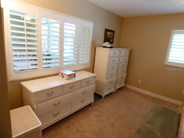 bedroom featuring light colored carpet and baseboards