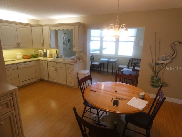 dining space with a notable chandelier, light wood-style flooring, and baseboards