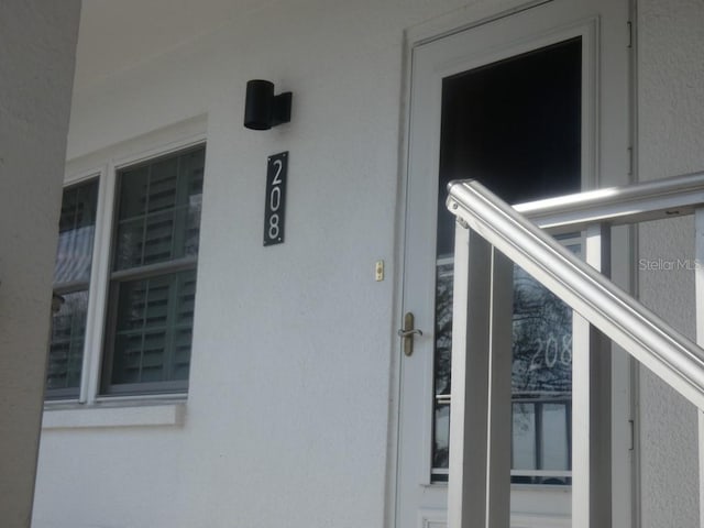 doorway to property featuring stucco siding