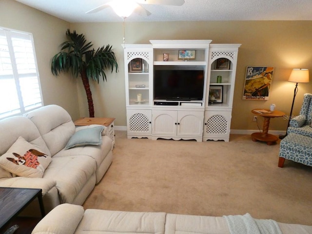 living area with light carpet, ceiling fan, and baseboards