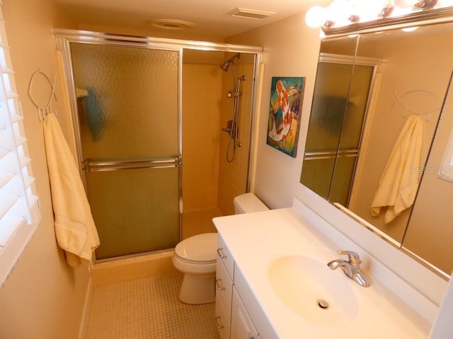 bathroom with a stall shower, visible vents, vanity, and toilet