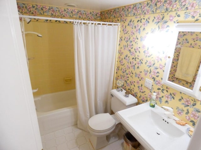 bathroom featuring toilet, wallpapered walls, shower / bath combo with shower curtain, and a sink