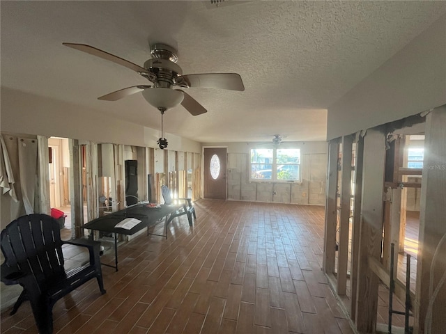 interior space with dark hardwood / wood-style flooring, ceiling fan, and a textured ceiling