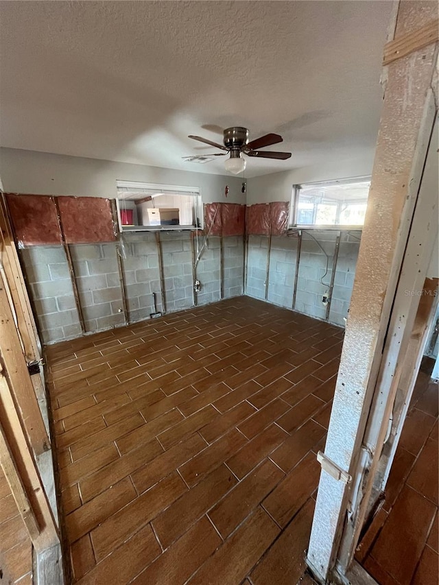 bonus room with ceiling fan, dark hardwood / wood-style floors, and a textured ceiling