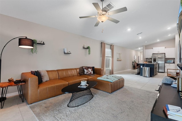 living room with lofted ceiling, sink, light tile patterned floors, and ceiling fan