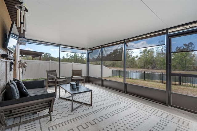 sunroom / solarium featuring a water view