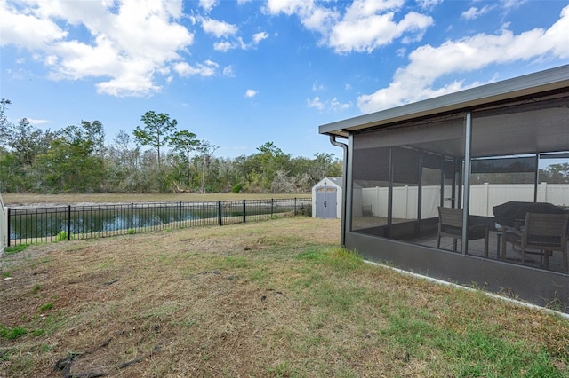 view of yard with a sunroom and a storage unit