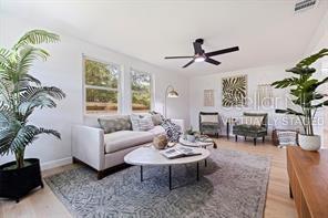 living room with wood-type flooring and ceiling fan