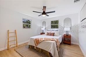 bedroom featuring multiple windows, ceiling fan, and light wood-type flooring