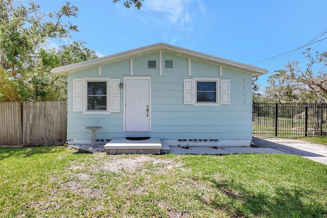 view of front of property featuring a front lawn, fence, and crawl space