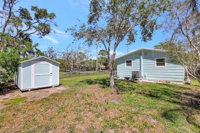 view of yard with a storage shed, fence, and an outdoor structure