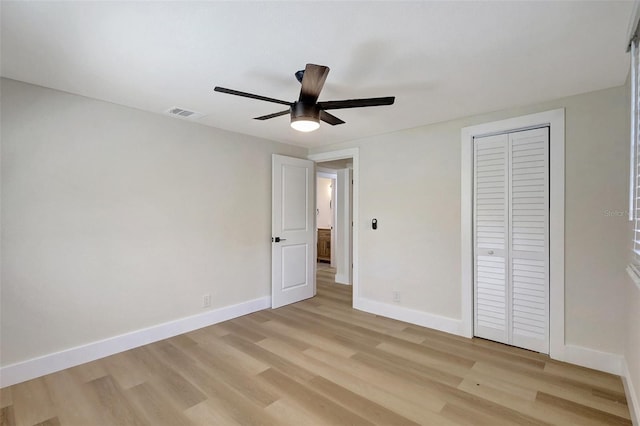 unfurnished bedroom featuring ceiling fan, baseboards, a closet, and light wood-style flooring