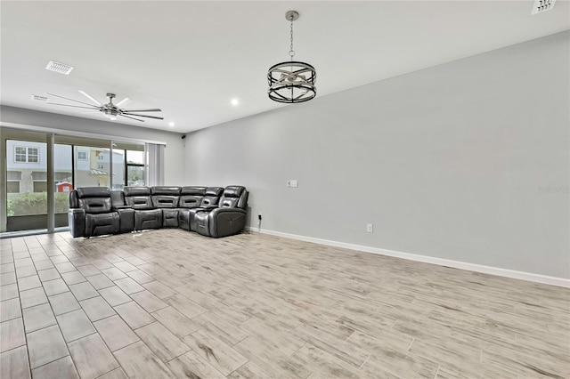 living room featuring ceiling fan with notable chandelier and light hardwood / wood-style floors