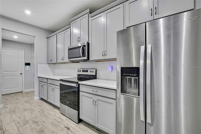 kitchen with backsplash, stainless steel appliances, and gray cabinetry