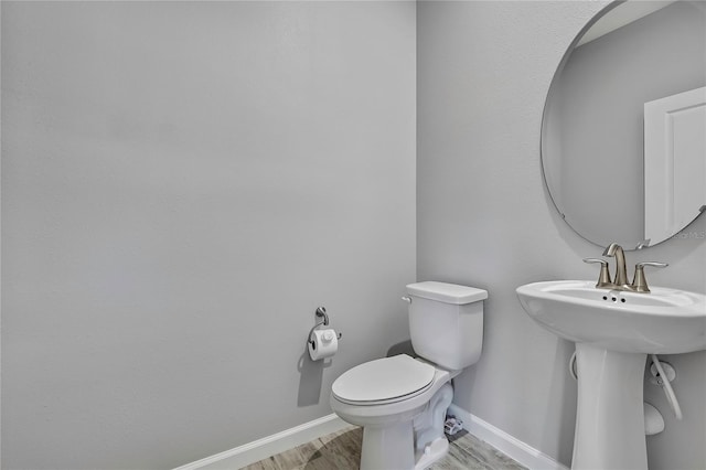 bathroom with wood-type flooring, sink, and toilet