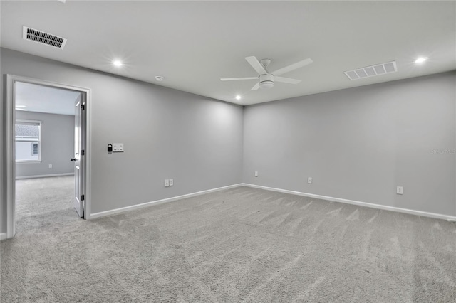 spare room featuring light carpet and ceiling fan