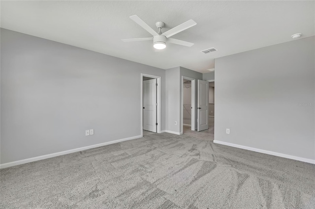 spare room with ceiling fan and light colored carpet