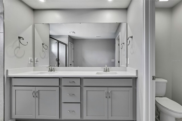 bathroom featuring vanity, an enclosed shower, and toilet