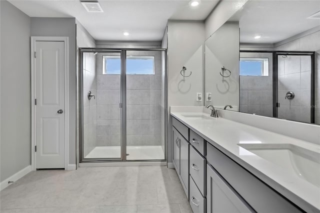 bathroom featuring tile patterned flooring, vanity, a healthy amount of sunlight, and an enclosed shower