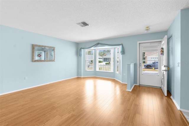 interior space with light hardwood / wood-style floors and a textured ceiling