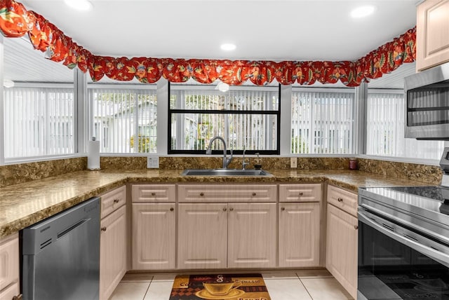 kitchen with appliances with stainless steel finishes, sink, and light tile patterned floors