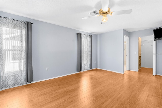 spare room with a textured ceiling, light hardwood / wood-style floors, and ceiling fan