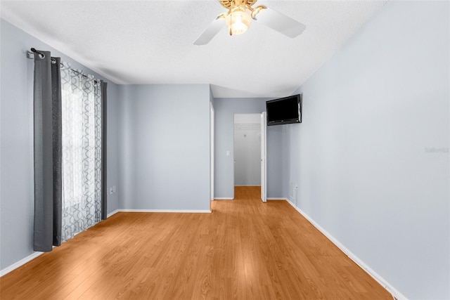 spare room featuring ceiling fan, light hardwood / wood-style floors, and a textured ceiling