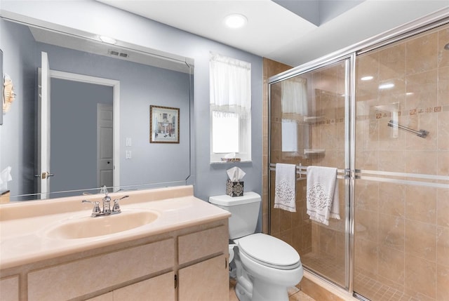 bathroom with vanity, a shower with door, and toilet