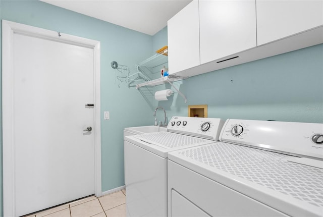 laundry room featuring separate washer and dryer, sink, cabinets, and light tile patterned flooring