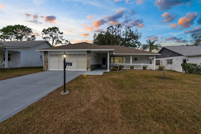 ranch-style house with a porch, a garage, and a yard