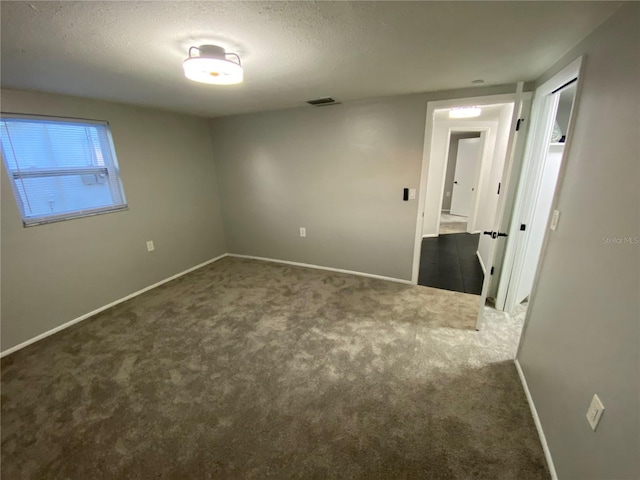 empty room featuring carpet and a textured ceiling