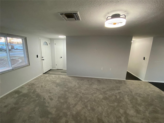 carpeted spare room with a textured ceiling