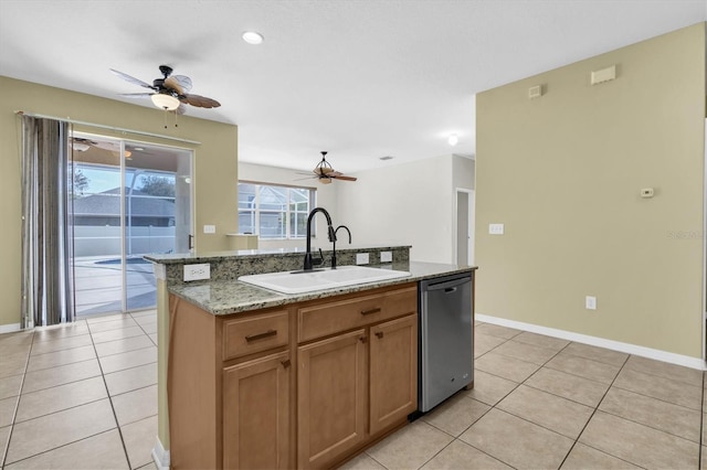 kitchen with a kitchen island with sink, dishwasher, sink, and light stone countertops