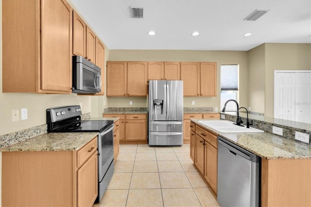 kitchen featuring light brown cabinetry, sink, stainless steel appliances, and light stone countertops