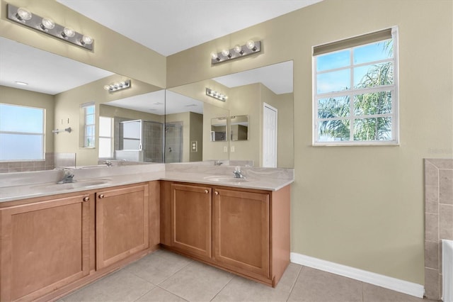 bathroom with tiled shower, vanity, and tile patterned flooring