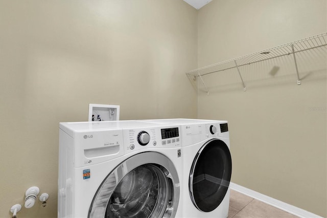 clothes washing area with light tile patterned floors and independent washer and dryer