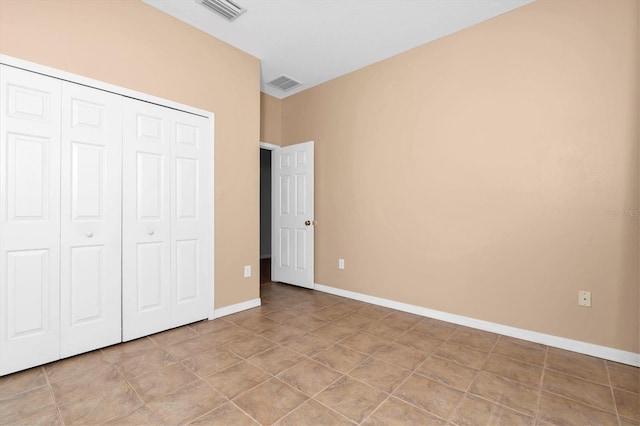 unfurnished bedroom featuring light tile patterned floors and a closet