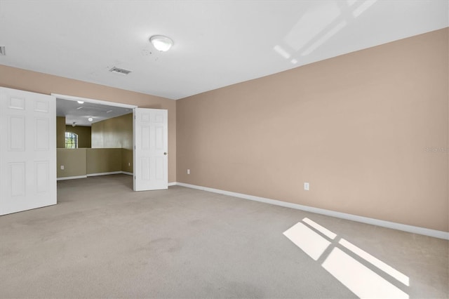 spare room featuring light colored carpet