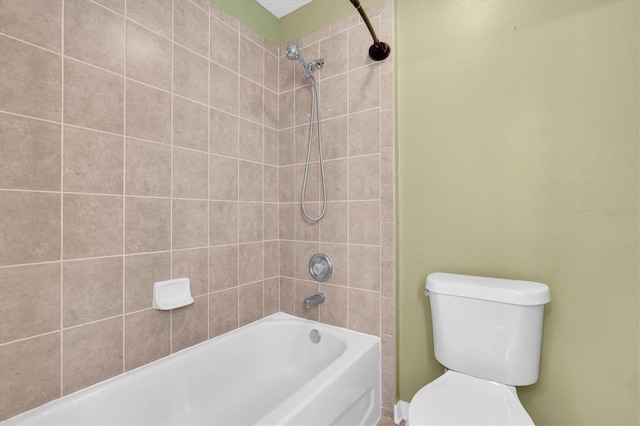 bathroom featuring tiled shower / bath combo and toilet