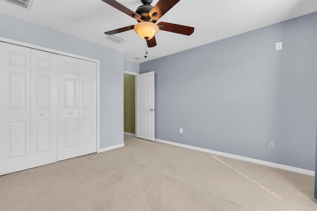 unfurnished bedroom featuring ceiling fan, light carpet, and a closet