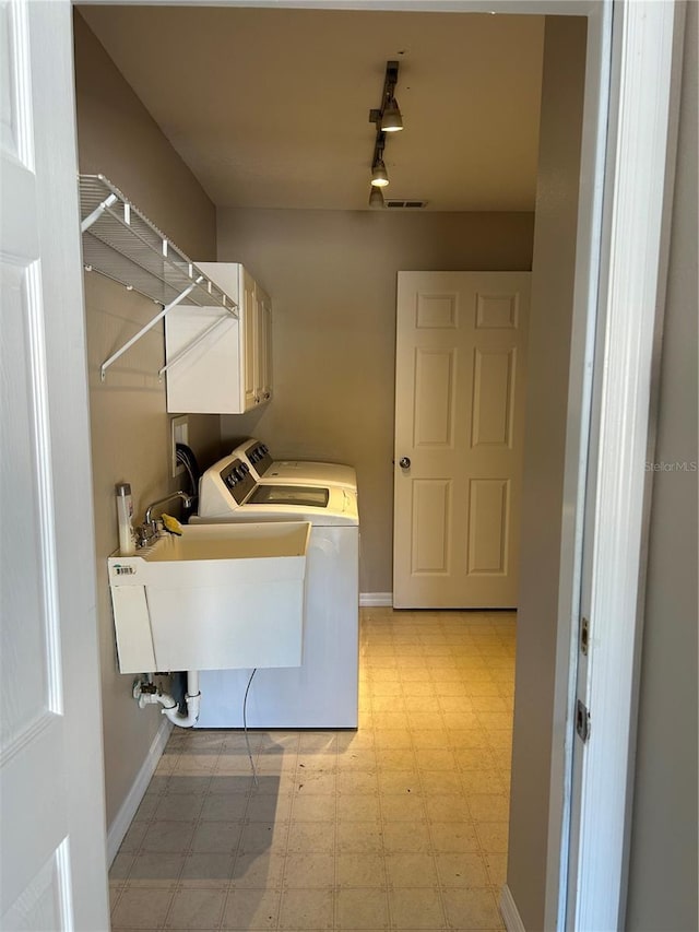 laundry area featuring cabinets, washer and dryer, and sink